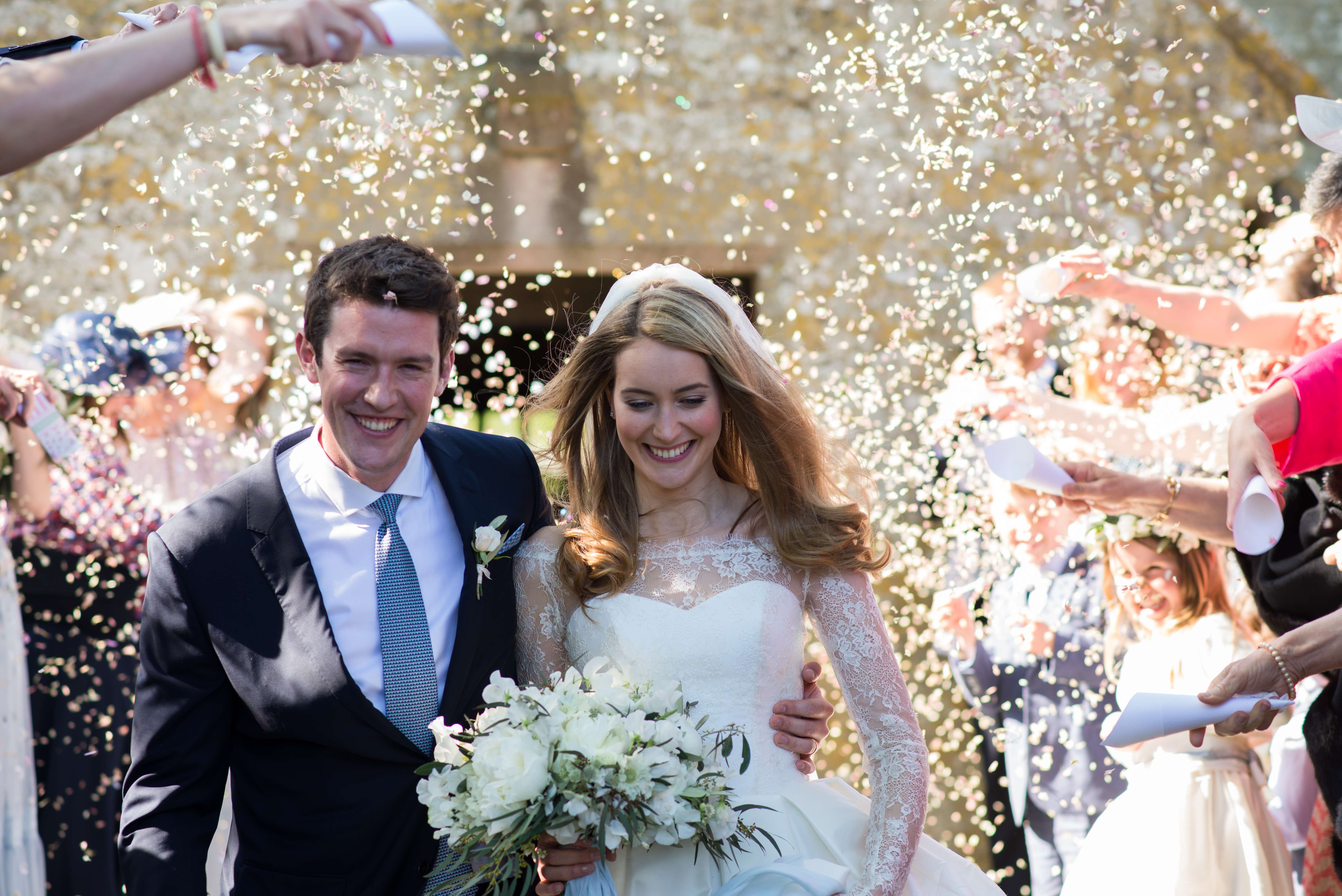 bride and groom with confetti outside the church in dorset by especially amy wedding photography